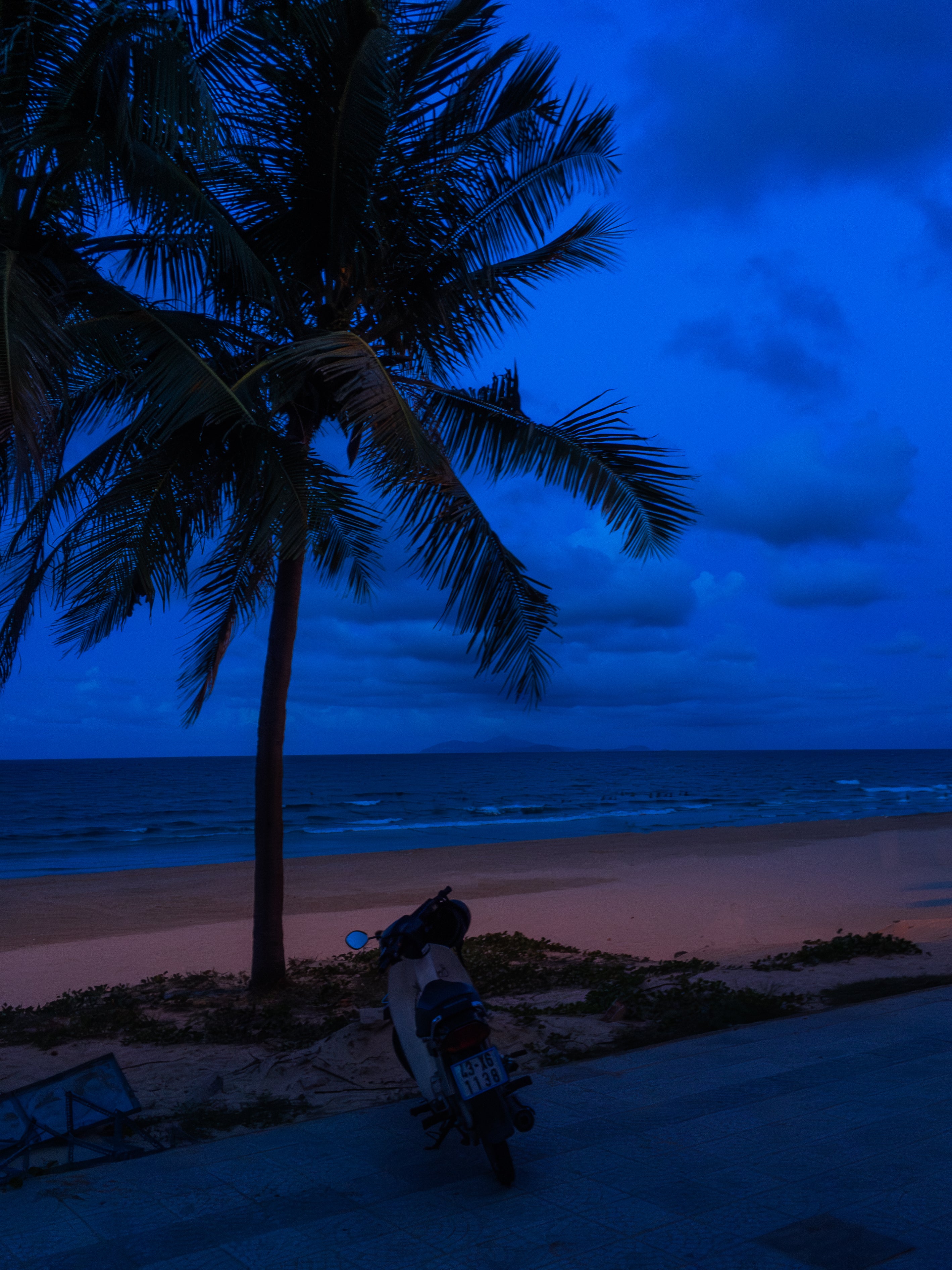 Vietnam's Beach: Motorcycle Rests on Serene Beach | Poster